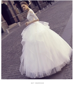 Exquisite lace floral embroidery and layered mesh skirt of this white bridal gown