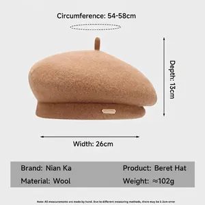 Béret élégant en laine de chameau pour femme avec logo en métal doré sur fond plat gris