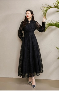 Detail view of a black lace long sleeve dress featuring V-neck and pleated waist buttons