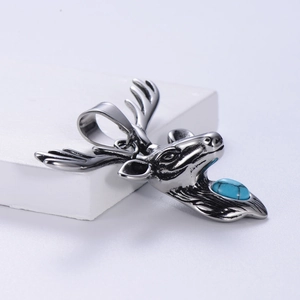 Pendentif tête d'élan en acier inoxydable avec pierre turquoise bleue sur socle blanc