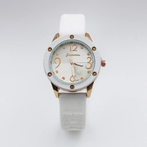 Detail of white silicone strap watch with golden heart dial and rivet decorated case