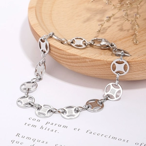 Detailed close-up of a silver hollow-grid coin bracelet on a wooden tray decor