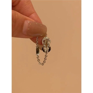 Detailed view of a gold-plated horseshoe buckle ring with micro-set crystals and chain