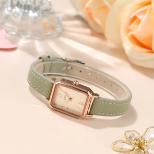 Elegante rechteckige Damenuhr mit Roségoldgehäuse und grünem Lederarmband auf Rosendekor
