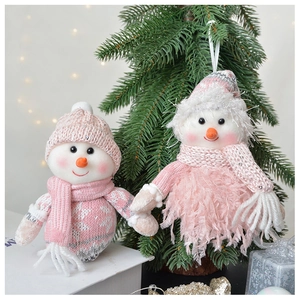Close-up of pink knitted snowman figures with intricate scarves on a festive tree branch