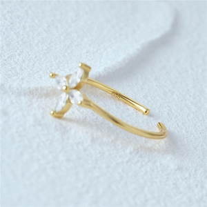 Macro detail of S925 sterling silver gold plated ear cuff with white zircon flower