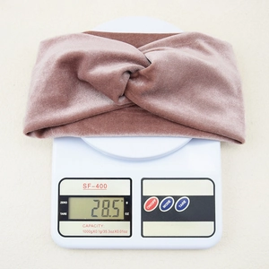 Detail showing a dusty pink velvet crossover headband weighing 28.5g on a scale