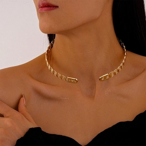 Detail of twisted gold metal choker necklace showing intricate braided texture and finish