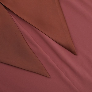 Vue macro de la texture du tissu tissé rouge foncé et des coutures superposées