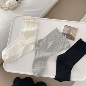 Detail of cotton mesh socks showing ruffled edges and vertical ribbed texture in three colors