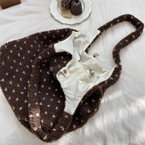 Detail of plush brown polka dot tote bag showing ivory lining and internal pocket storage