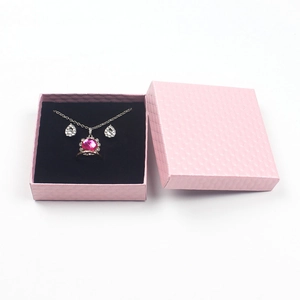Detailed top view of a pink textured jewelry gift box with rose red gemstone jewelry set