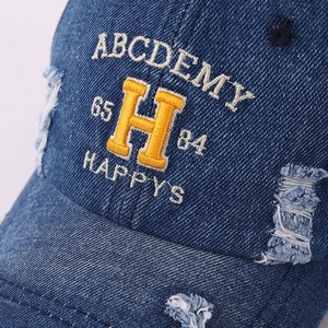 Vintage distressed denim baseball cap with yellow letter embroidery and ripped details