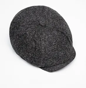 Top view of dark grey tweed newsboy cap showing classic herringbone texture and button top