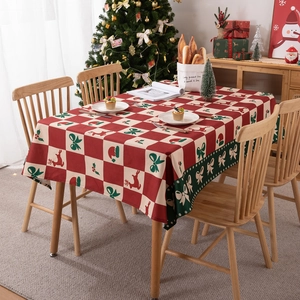 Christmas tablecloth with red green plaid elk pattern on wooden table with holiday decor