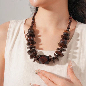 Detailed view of handmade wood and coconut shell beaded necklace on female neck