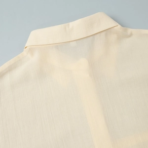 Macro shot of light yellow shirt collar showing high-quality stitching and breathable fabric