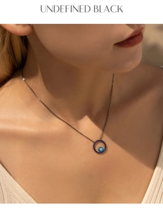 Close-up of model wearing S925 silver black necklace with blue crystal Evil Eye pendant