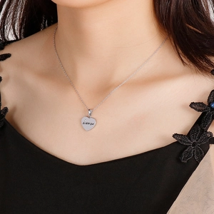 Macro shot of silver heart pendant with ELINCA engraving and a small inlaid zircon stone