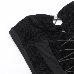 Detail of black lace jumpsuit featuring butterfly flocking and cross-lace design