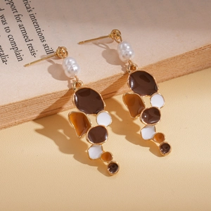 Detail of vintage drop earrings with imitation pearls and colorful enamel on book pages