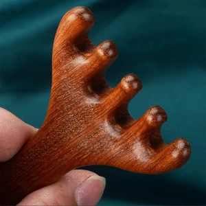 Detailed close-up showing the smooth wood grain and unique texture of the five-tooth massage comb