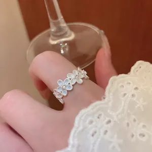 Elegant silver open ring with five mother-of-pearl flowers and diamonds on model hand