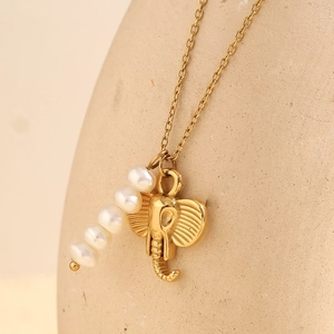 18K gold plated elephant and pearl pendant necklace displayed on a beige jewelry stand