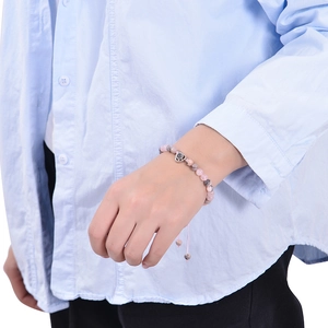 Detail of pink and grey map stone beaded bracelet with heart pendant on wrist