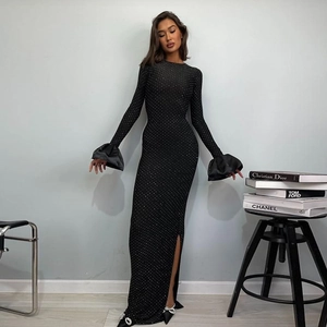 Détail d'une robe de soirée noire avec strass scintillants et poignets à volants en satin