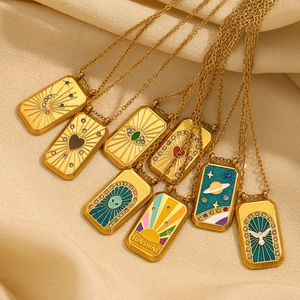 Détail de 8 colliers tarot dorés avec motifs en émail colorés sur tissu beige doux