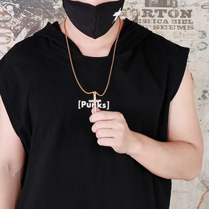 Gros plan d'un collier croix or 18 carats serti de cristaux sur un mannequin homme