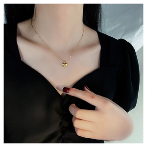 Elegante collar con colgante de corazón dorado y amuleto 3D pulido minimalista en modelo