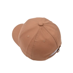 Top view of a tan cotton baseball cap showing stitching and adjustable metal buckle