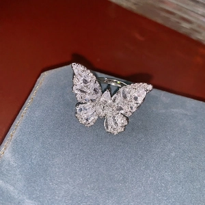 Bague papillon tendance avec zircons étincelants sur un coffret en velours bleu