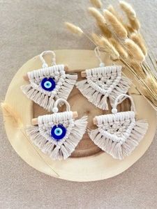 Detailed macro view of four macrame evil eye pendants on a natural wooden tray decor