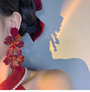 Detailed view of large 3D red rose flower earrings with delicate silk fabric petals