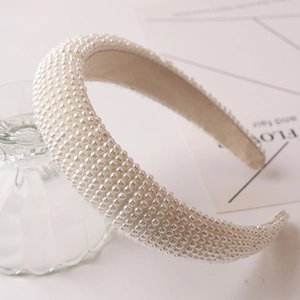 Close-up of a wide vintage headband with hand-beaded ivory pearls and soft lining