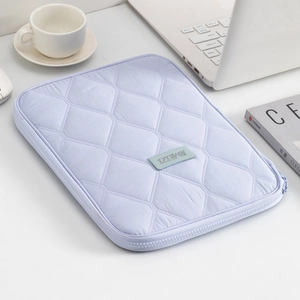 Close-up of a light purple quilted laptop sleeve with diamond patterns on a desk