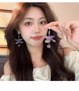 Detail of purple resin flower earrings with delicate tassel and rhinestone accents