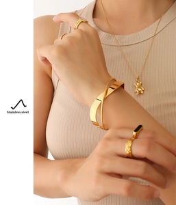 Polished 18K gold plated stainless steel jewelry set on model with rings and bracelet