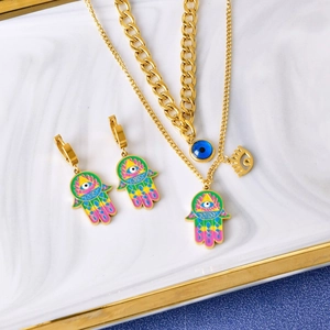 Golden Hamsa hand and Evil Eye jewelry set with colorful enamel on marble tray