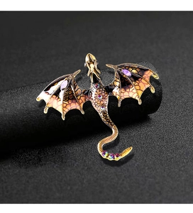 Macro detail of enamel dragon brooch showing gold scales and colorful inlaid gemstones