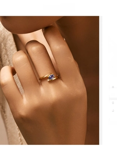 Detail of cross open 18K gold ring with oval purple gemstone and accent diamond