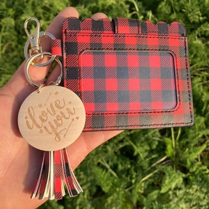 Detail of red and black buffalo plaid card holder with tassel and wood charm