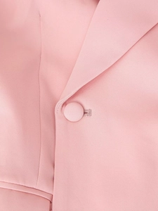 Detailed macro view of pink blazer fabric texture with a matching fabric-covered button