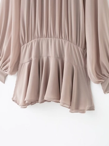 Détails de la robe en mousseline rose poudré avec taille plissée et texture fluide