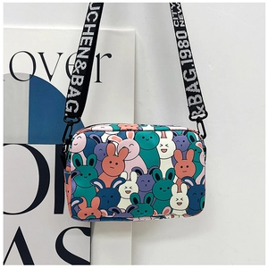 Detail of canvas crossbody bag with colorful rabbit print and lettered webbing strap