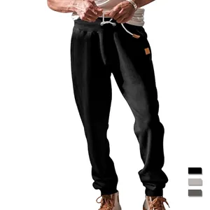 Men's solid color joggers with elastic drawstring waist and leather detail accents