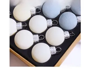 Detailed view of flocked 3cm Christmas balls in white and grey with silver hanging loops
